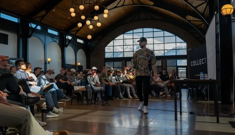 A wide view of the same event, Cory walking the front of the room as the audience watches.