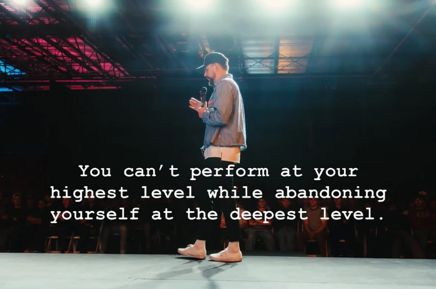 Cory speaking on a darkened stage, with the line “You can’t perform at your highest level while abandoning yourself at the deepest level.” across the image.